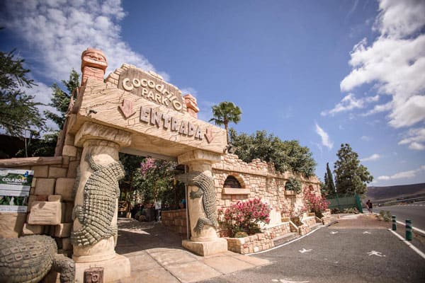 Entrada al parque Cocodrilo Park, en la foto se ve el cielo azul, la entrada está compuesta por dos columnas de pieda talladas las figuras de dos cocodrilos